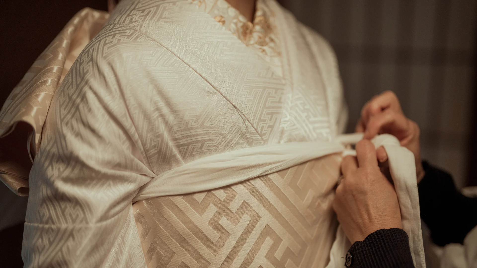 A bride’s traditional kimono being carefully prepared, symbolizing the spiritual and cultural significance of Shinto weddings. Shinto Wedding Ceremony