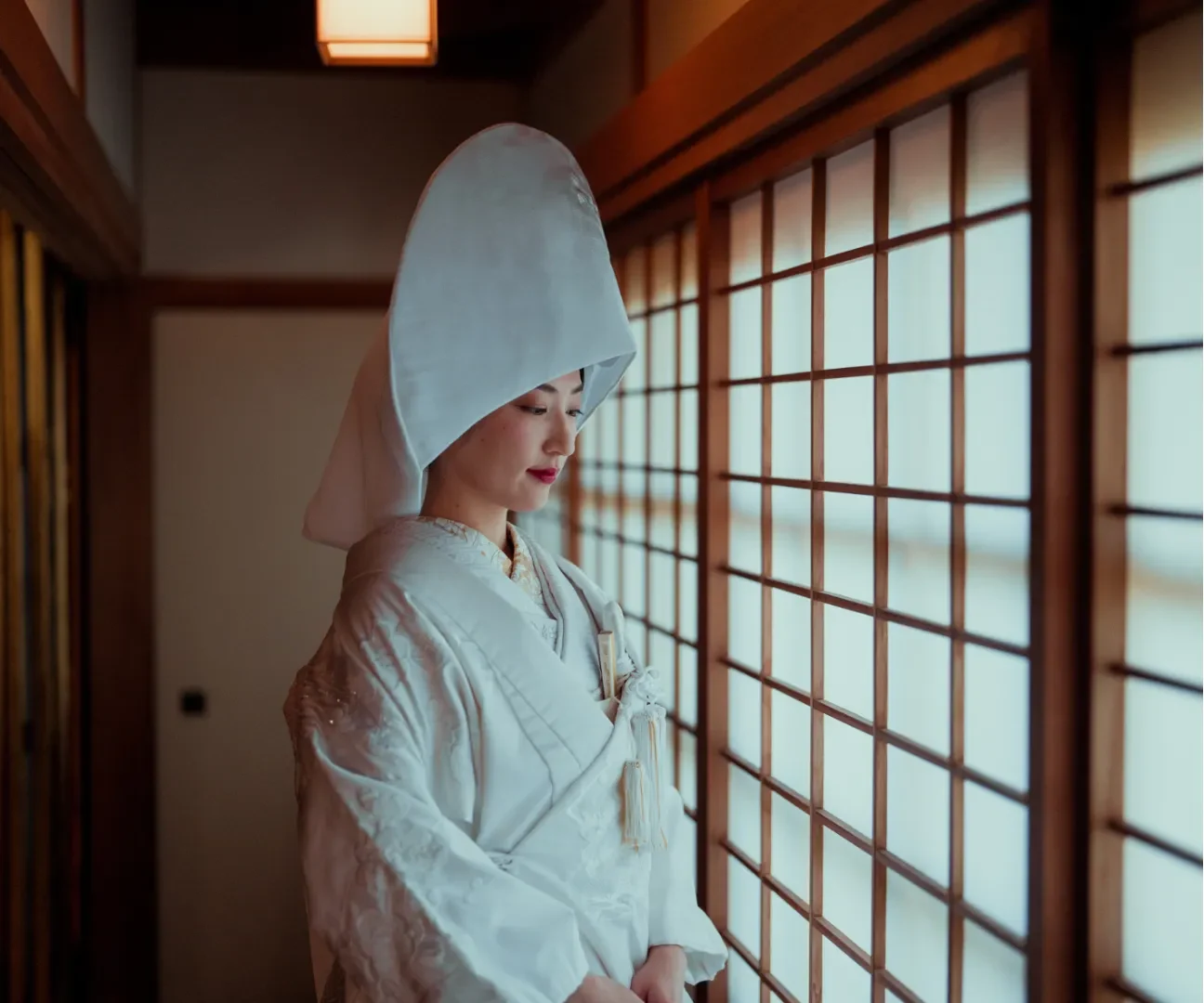 A Japanese bride wearing a wataboshi, a traditional hood symbolizing modesty and purity, paired with a sophisticated hairstyle that enhances cultural connection.
