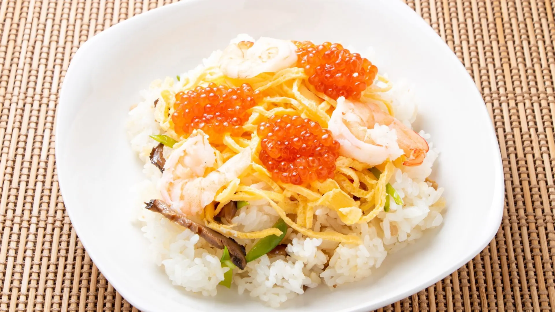 Chirashi-sushi (ちらし寿司) – scattered sushi with shrimp, egg ribbons, mushrooms, and bright orange ikura (salmon roe) served at a Japanese wedding