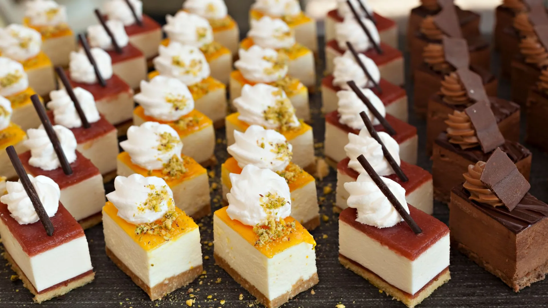 Wagashi-inspired dessert buffet at a Japanese wedding with mini cheesecakes topped with fruit, whipped cream, and pistachios