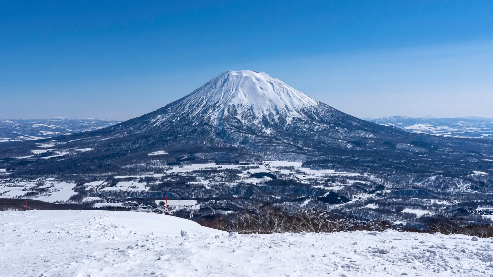 Iconic snow-covered Mount Yotei volcano in winter with vast snowy landscape, Hokkaido Japan